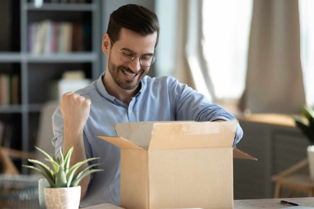 happy 30s young man celebrating getting purchase from internet store 207761398